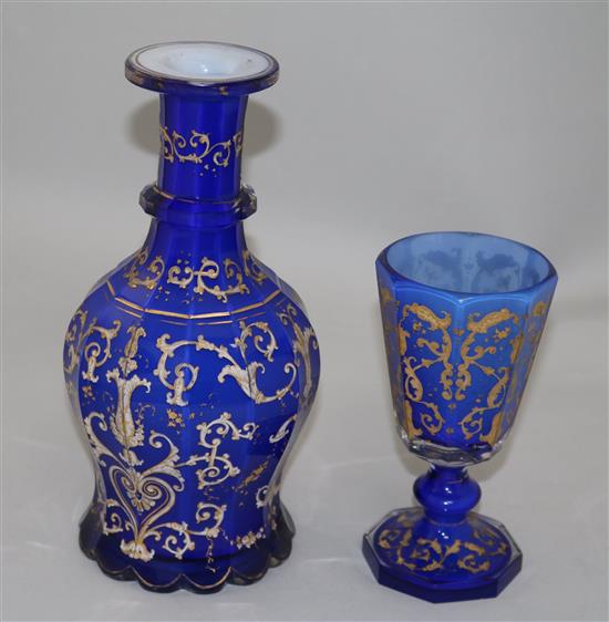 A Bohemian gilt decorated and white enamelled blue glass decanter and matching goblet, late 19th century, 26.5cm and 17.3cm, manufactur